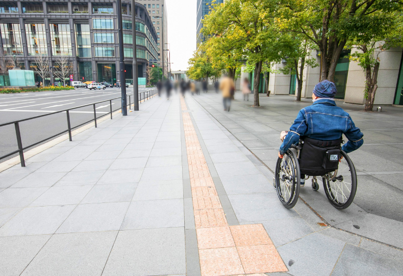 写真：車いす使用者が歩道をまっすぐ移動する様子