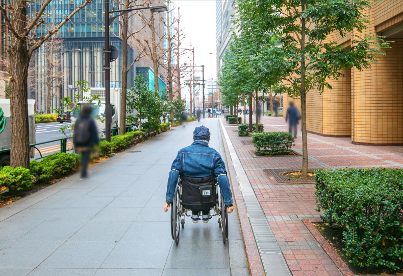 写真：車いす使用者が歩道をまっすぐ移動する様子