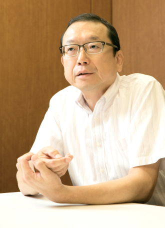 北関東・信越総合料金センター　所長　上杉明男さんのインタビューのバストショット。落ち着いたまっすぐな視線でインタビューに答えている様子。