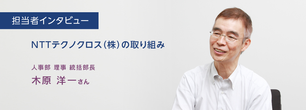 担当者インタビュー　NTTテクノクロス（株）の取り組み　人事部　理事　統括部長　木原洋一さんのインタビューのバストショット。にこやかにインタビューに答えている様子。