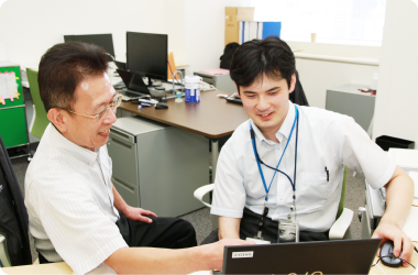 写真：小林さんと永田さんがパソコンを見ながら打ち合わせをしている様子