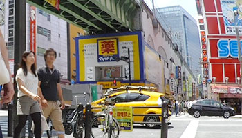 写真：総武線の高架と電気店が立ち並んでいる様子