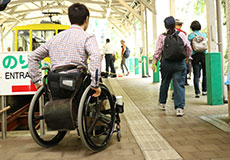 写真：清滝駅の乗り場のスロープを車いすで登っている様子