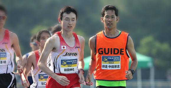 写真：左は視覚障がい者のマラソン選手、右に伴走する中田崇志さん。二人で走っている正面からの様子