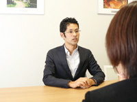 写真：インタビュアーと向き合って質問に答えている中田さんの様子