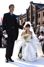 写真：ピロレーシング（UDウェディングドレス）を着た花嫁が父に手を引かれてバージンロードを歩いている様子