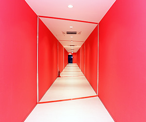 写真：赤い壁と天井と床が白い廊下の様子。