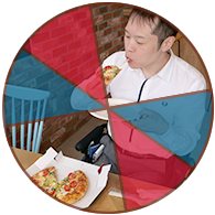 写真：ピザを食べている編集部員、チーズがとろりと伸びている
