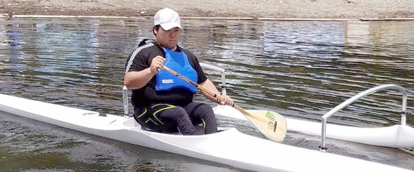 写真：カヌーに乗りヴァーのパドルで水をかく小山選手