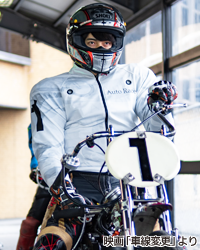 写真：幸助役の平田雄也さんがオートバイに乗っている様子