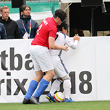 写真：日本選手と相手選手がサイドフェンスの所でボールを奪い合っている模様
