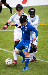 写真：日本選手と相手選手でボールを奪い合っている所の模様