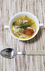 写真：野菜がたっぷりのスープ、トッピングにあらびき胡椒をふるかけている