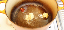 写真：鍋に油と調味料を入れている