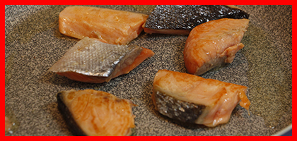写真：フライパンで塩鮭を焼いている様子