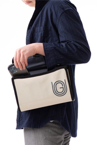 写真：女性が肩からバッグをかけてスマートフォンを取り出している様子