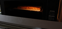 写真：成形された生地をオーブンで焼いている