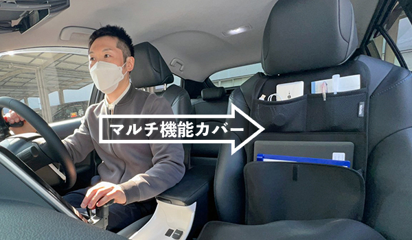 写真：運転席に乗っている編集部員、助手席に小物を収納しているマルチ機能カバー