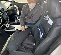 写真：運転席の編集部員が助手席のマルチ機能カバーを取り付けている