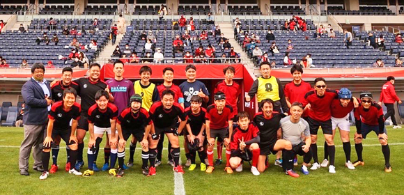写真：アルコバレーノ東京の選手が対戦相手と二列にならんで笑顔で肩を組んでいる