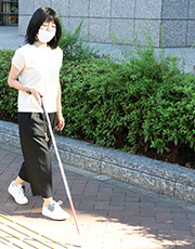 写真：編集部員が「あしらせ」を装着して歩道を歩いている