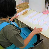 写真：机上で漉いた紙を作業する女性の後ろ姿