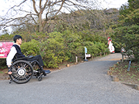 画像：急な登り坂の前に車いすユーザがいる