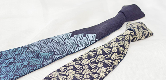 写真:青色のネクタイとベージュの花柄のネクタイが置かれている。