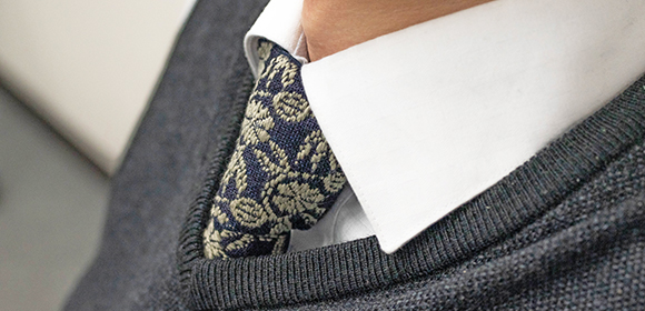 写真：ネクタイをつけた首元がズームされている。
