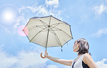 写真：太陽に向かってサイレントアンブレラを差す女性
