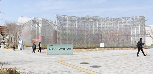 写真:NTTパビリオンの建物
。外壁の外側には多くの灰色の布が飾られている。