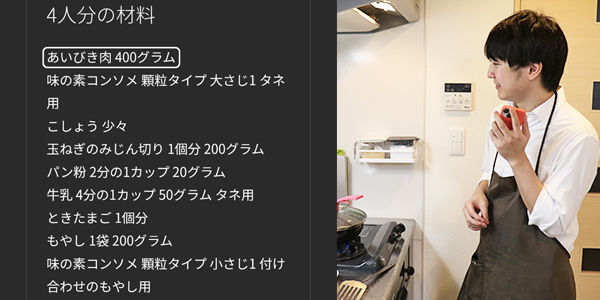 写真:つくり方のスマホ画面とそえを聴いているエプロン姿の視覚障がいの男性社員