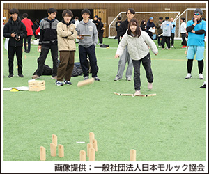 写真：室内の人工芝の上で「モルック」をやっている所