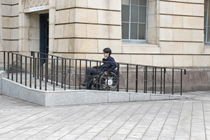 写真：本堂わきのスロープをのぼる車いすユーザ