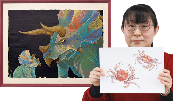 写真：ドットが印象的な恐竜の絵を背景に日本画風の蟹の絵を持つシオさん