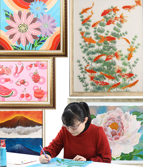 写真：植物や自然、恐竜などの作品を背景にシオさんが絵を描いている